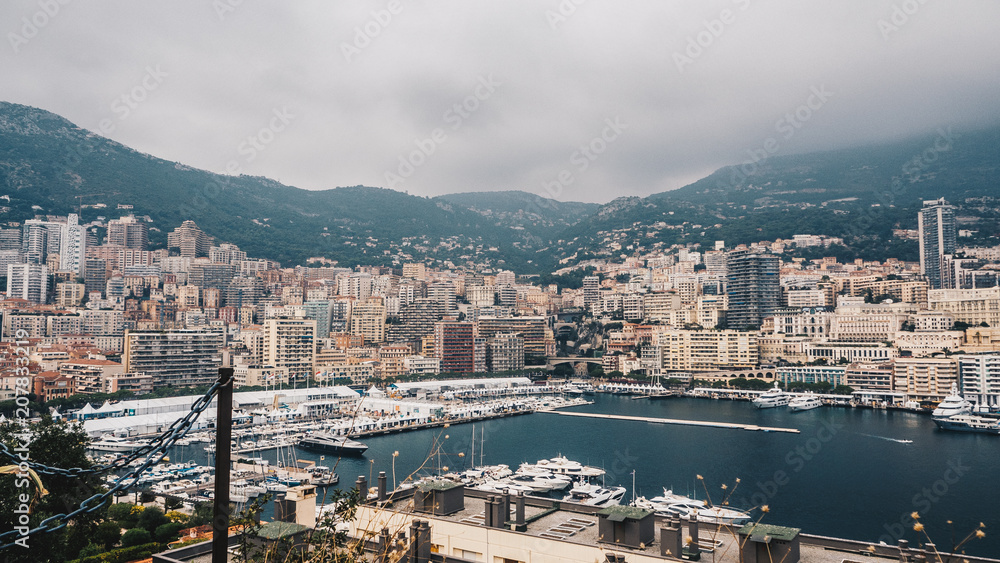 Scenic panorama of Monte Carlo from the observation deck. Roofs of houses and buildings and hills on background. Sailing boats and yacht harbour, port. Aerial top view. France