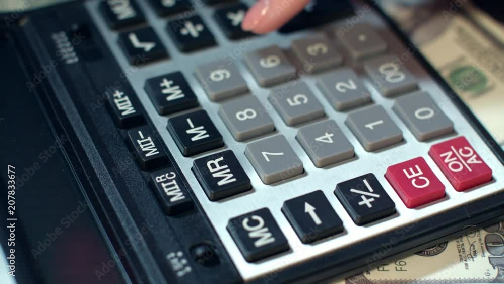 Business woman hand using calculator at office. Close up of financial adviser working with calculator. Business accounting calculating money profit. Calculator on background of dollar banknotes Business woman hand using calculator at office. Close up of financial adviser working with calculator. Business accounting calculating money profit. Calculator on background of dollar banknotes