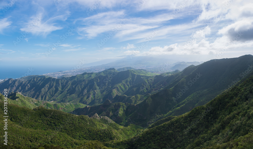 Beautiful panoramic view of the Anaga Mountains. Green hills, colorful sky and deep blue ocean. Tenerife, Canary Islands