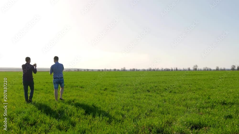 Couple of farmers in field using digital tablet. Two farmer standing in a field and looking at tablet. They are examining corp. Crop plant examined by two farmers. Couple of farmers in field using digital tablet. Two farmer standing in a field and looking at tablet. They are examining corp. Crop plant examined by two farmers.