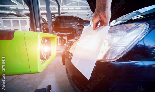 Worker checks and adjusts the headlights of a car's lighting system