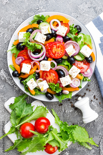 Greek salad. Fresh vegetable salad with tomato, onion, cucumbers, pepper, olives, lettuce and feta cheese. Greek salad on plate