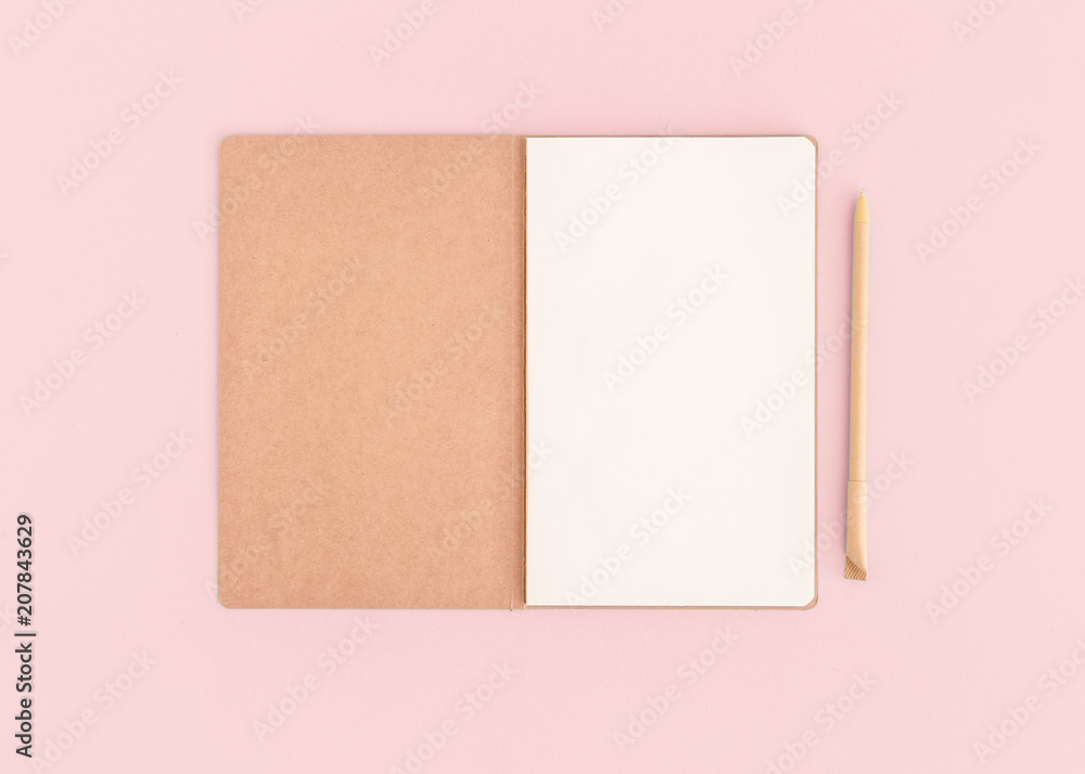 Fototapeta premium Pink desktop with notebook opened page and pen.
