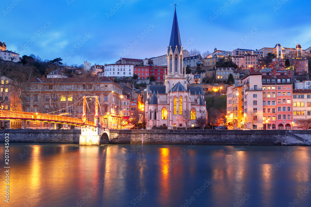 Panoramic view of Saint Georges church and footbridge across Saone river in the Old town during evening blue hour, Lyon, France