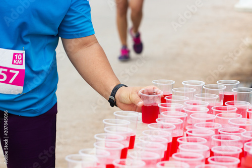 Marathon runner picking up mineral salt water at service point