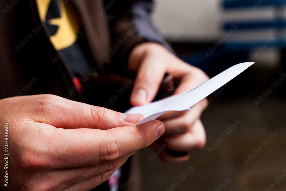 Businessman looking to an empty paper. Empty white paper in man's hands. Male holding sheet of paper. Human holds a note paper. Business concept. Copy space for text.