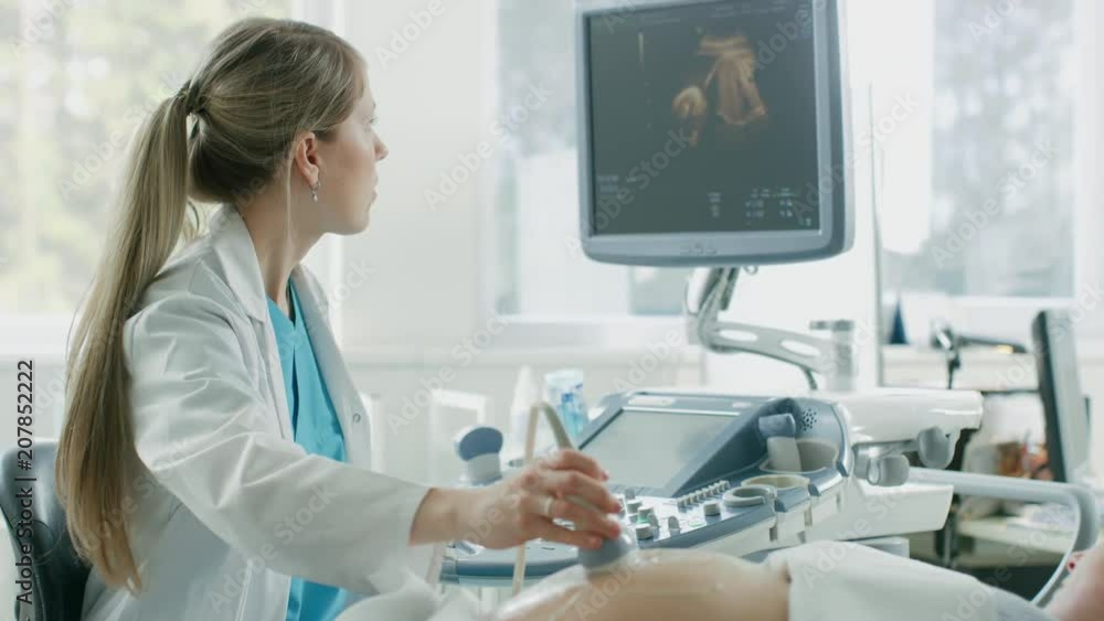 In the Hospital, Obstetrician Uses Transducer for Ultrasound/ Sonogram Screening / Scanning Belly of the Pregnant Mother. Shot on RED EPIC-W 8K Helium Cinema Camera. In the Hospital, Obstetrician Uses Transducer for Ultrasound/ Sonogram Screening / Scanning Belly of the Pregnant Mother. Shot on RED EPIC-W 8K Helium Cinema Camera.