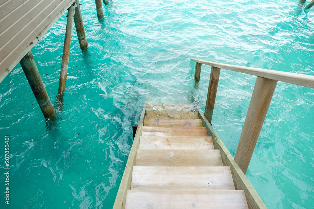 Stair down to crystal clear ocean from water villa private balcony, Maldives