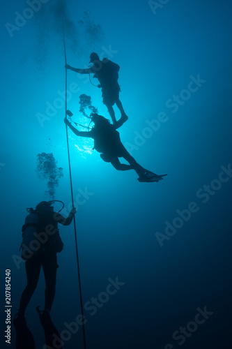Scuba divers on a line underwater