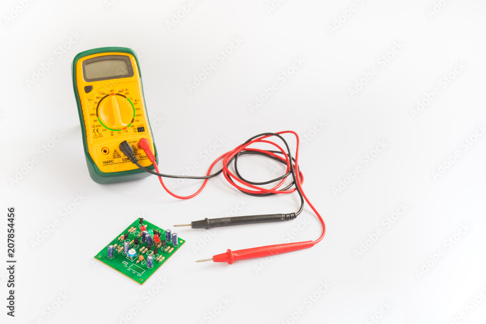 Electrical multimeter and PCB board on white background. Electrical multimeter and PCB board on white background.