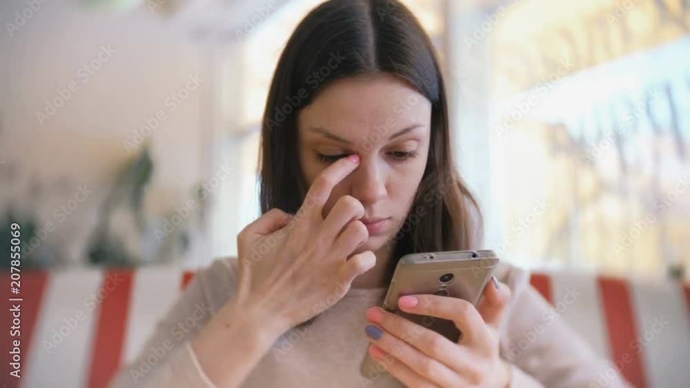 Young beautiful woman brunette typing and sending message in her mobile phone in cafe and waiting her friends. Young beautiful woman brunette typing and sending message in her mobile phone in cafe and waiting her friends.