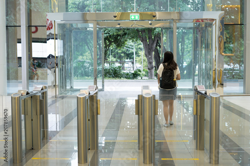 women people walking out from security at an entrance gate with key card access control smart office building