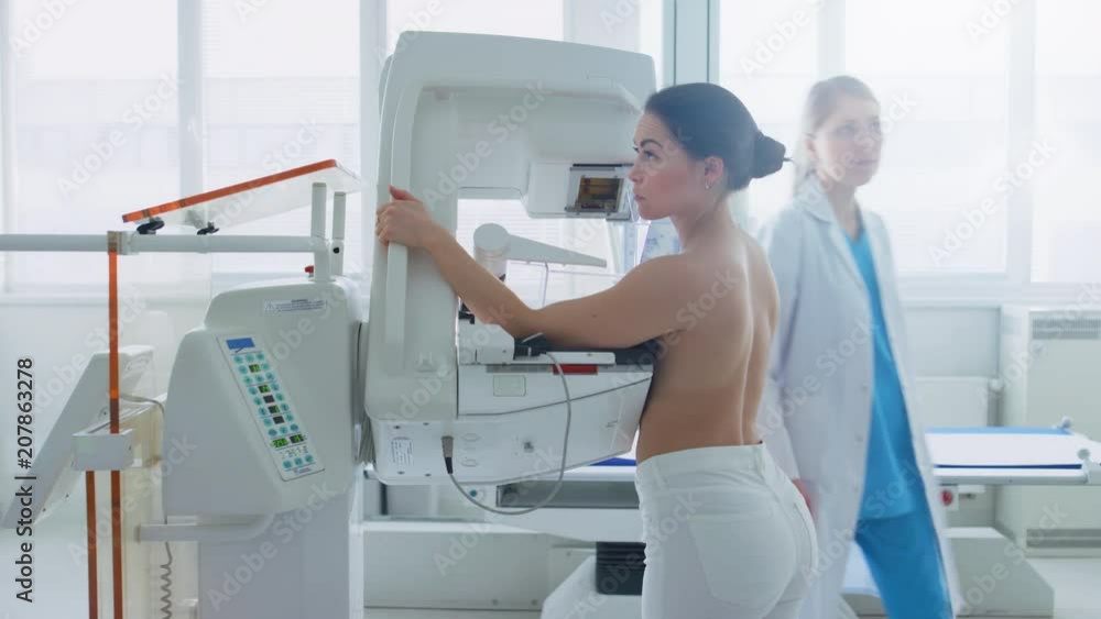 In the Hospital, Side View Shot of Topless Female Patient Undergoing Mammogram Screening Procedure. Shot on RED EPIC-W 8K Helium Cinema Camera. In the Hospital, Side View Shot of Topless Female Patient Undergoing Mammogram Screening Procedure. Shot on RED EPIC-W 8K Helium Cinema Camera.