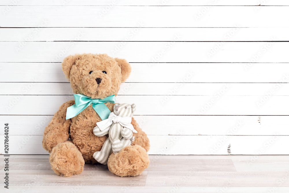 Two toy bears of parent and child on white wooden background. Parenthood concept. Copy space. Two toy bears of parent and child on white wooden background. Parenthood concept. Copy space.