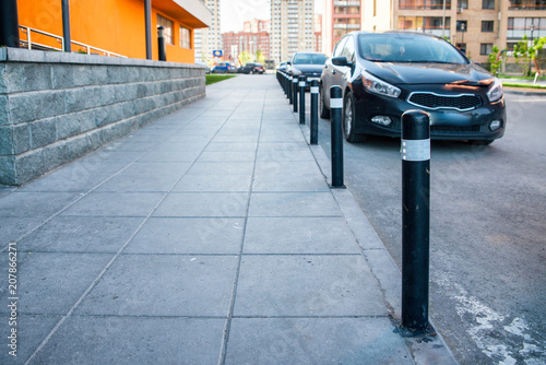 Bollards separating the roadway from the sidewalk in a residential area.