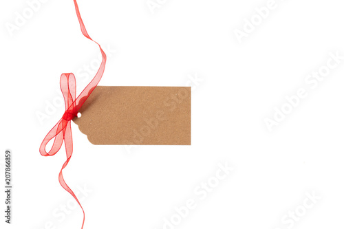 Beige isolated recycle tag with red satin ribbon top view on a white background