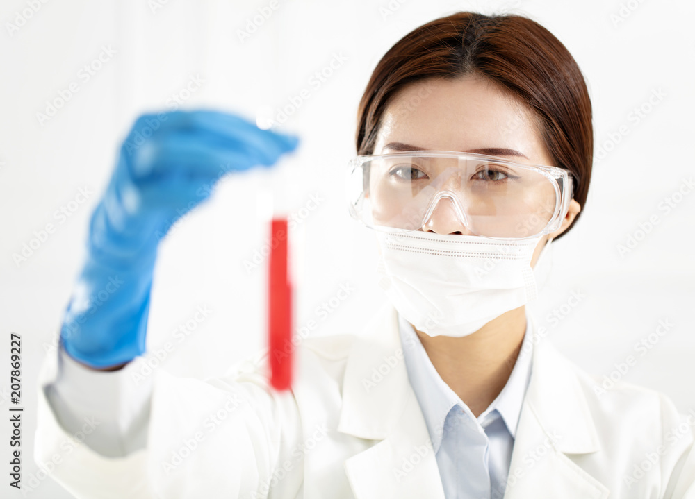 female scientist looking at test tube female scientist looking at test tube