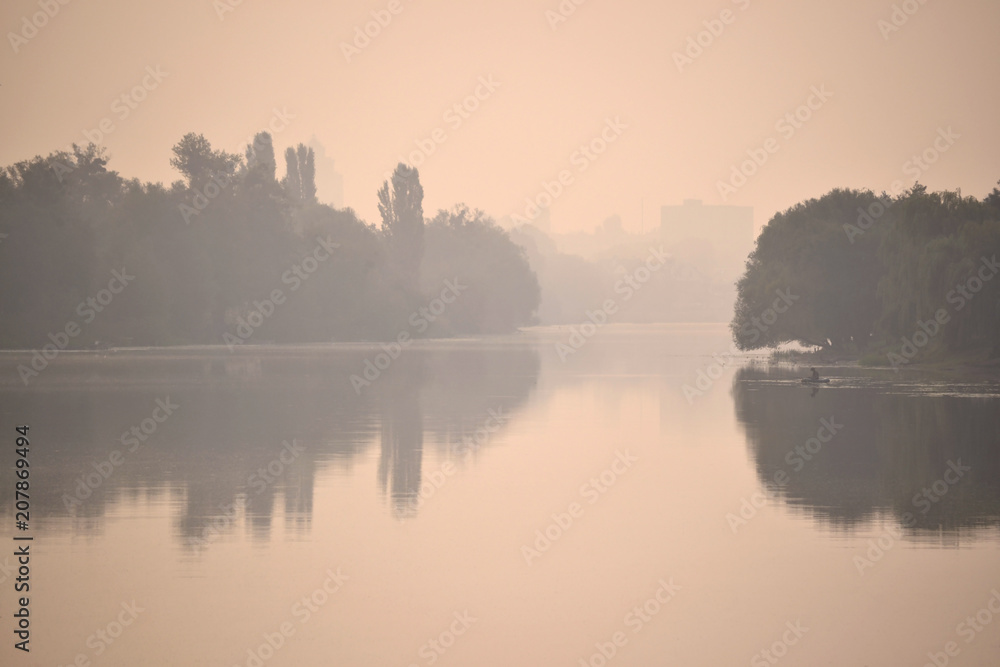 silhouettes of river banks in a pink fog mist at sunrise sunset