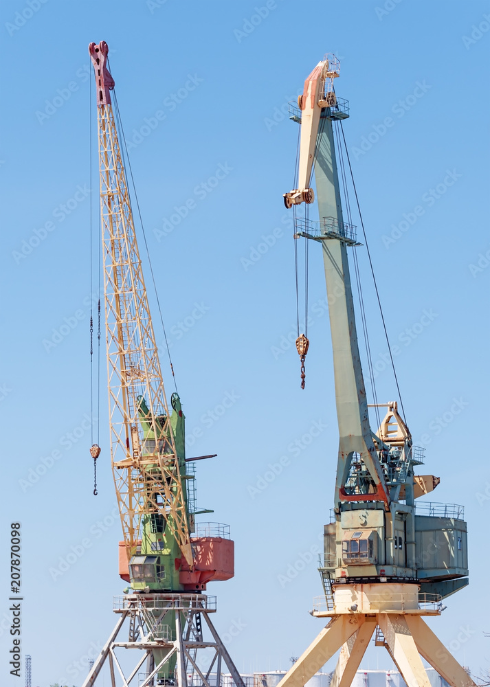 Port cargo cranes over blue sky