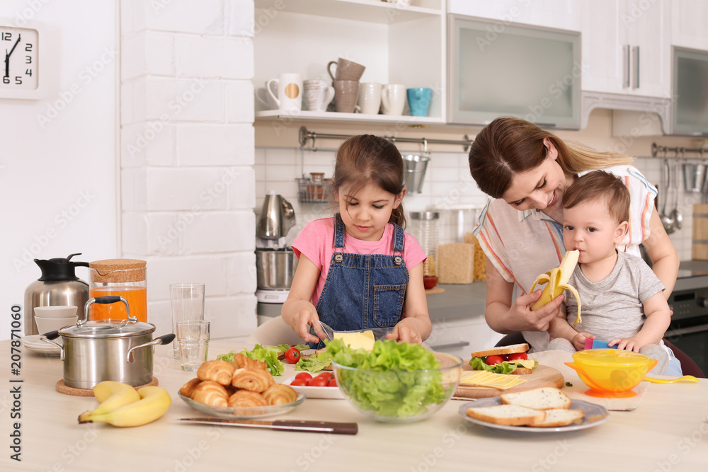 Housewife preparing dinner with her children on kitchen Housewife preparing dinner with her children on kitchen