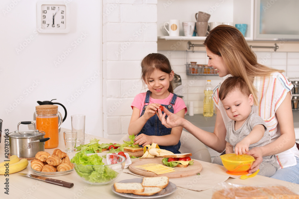Housewife preparing dinner with her children on kitchen Housewife preparing dinner with her children on kitchen