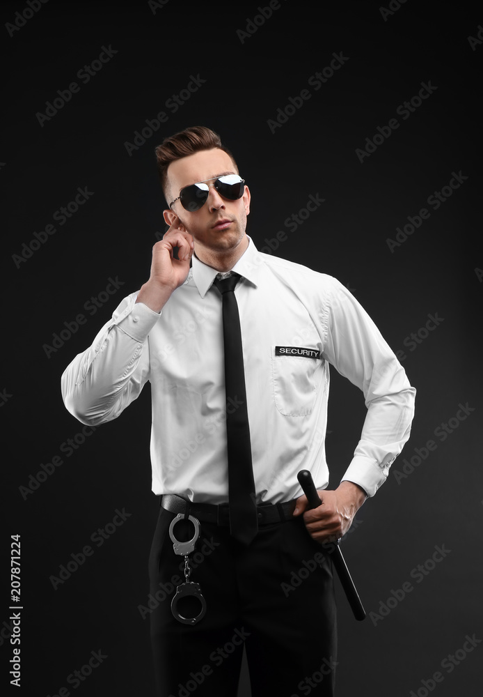 Obraz premium Male security guard in uniform on dark background