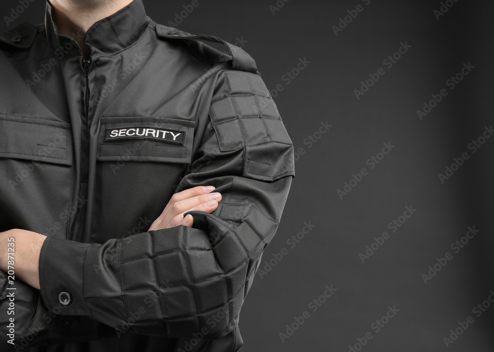 Male security guard in uniform on dark background, closeup - obrazy, fototapety, plakaty 