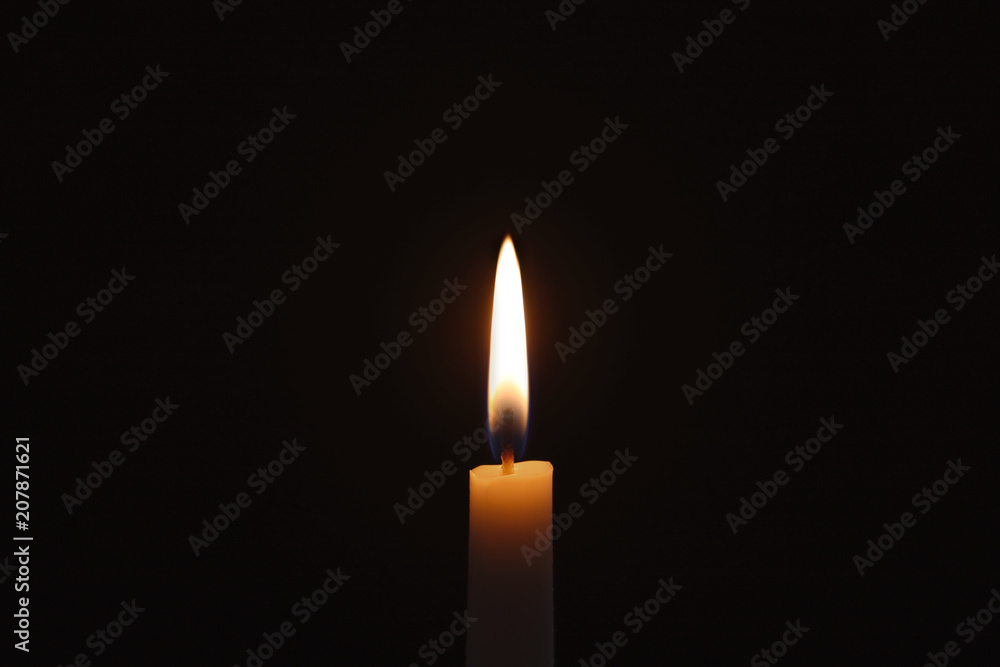 Wax candle burning on black background, closeup Wax candle burning on black background, closeup