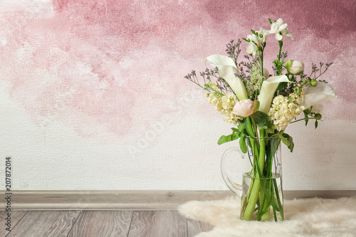 Fototapeta Naklejka Na Ścianę i Meble -  Vase with bouquet of beautiful flowers on floor