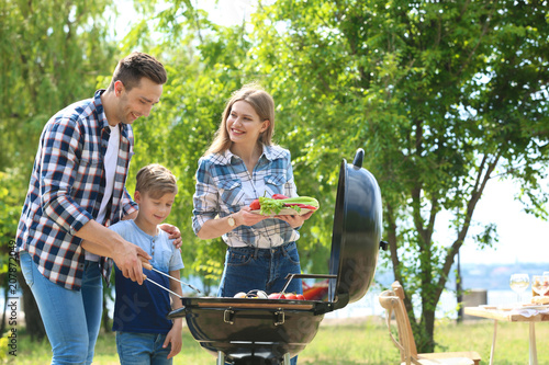 Photography Happy family having barbecue with modern grill outdoors