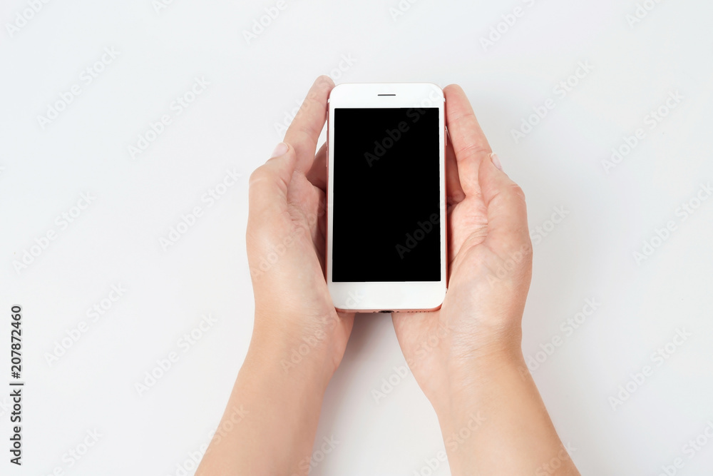 Young woman holding mobile phone with blank screen in hands on white background Young woman holding mobile phone with blank screen in hands on white background