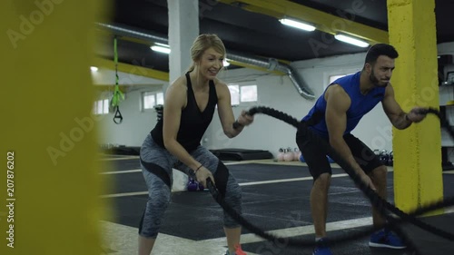 Wallpaper Mural Couple Doing Battle Rope Exercise in gym. . Torontodigital.ca