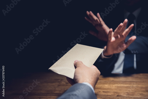 Businessman rejecting money in the envelope, anti bribery concept photo
