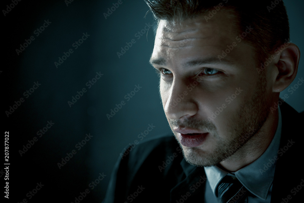 Man in shadow with serious face staring at interlocutor Man in shadow with serious face staring at interlocutor