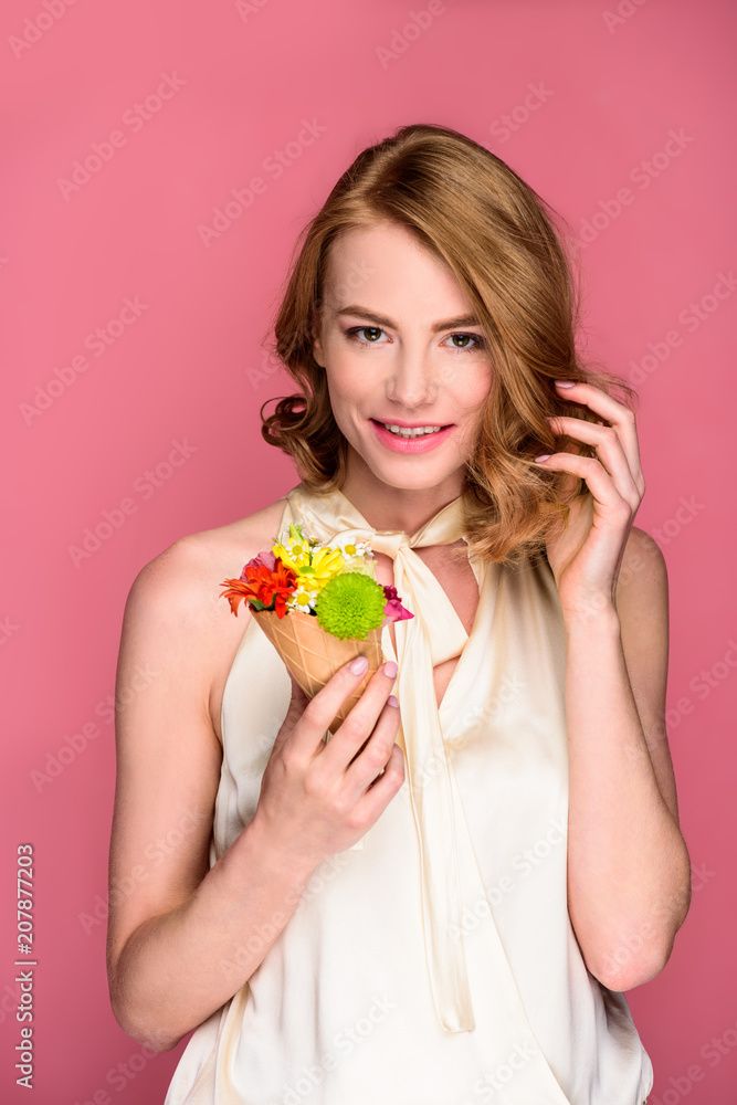 beautiful young woman holding wafer cone with flowers and smiling at camera isolated on pink beautiful young woman holding wafer cone with flowers and smiling at camera isolated on pink
