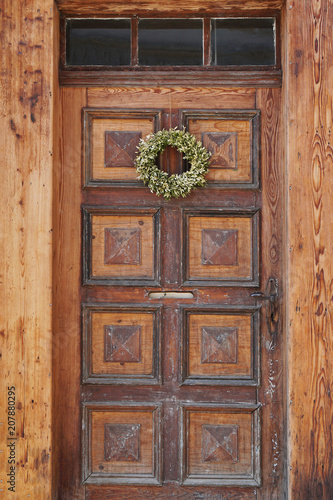 old shabby wooden front door with plain door wreath