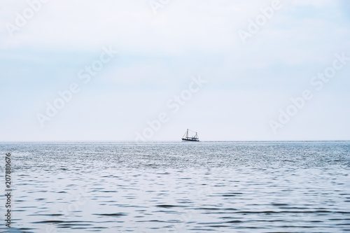 distant shrimp boat at the horizon, north sea in Germany