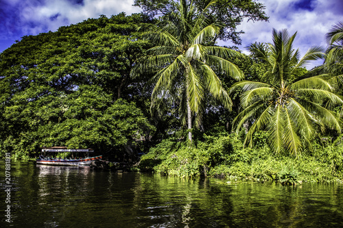 Colorful Tour Boat Parked at an Island with Tropical Palm Trees at the Isletas de Granada in Granada, Nicaragua