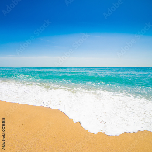 Beautiful Tropical beach with Soft wave of blue ocean, sand and transparent sky. Summer travel holiday background concept. Sea panorama.