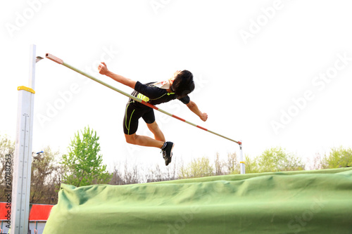 A male athlete is on the high jump