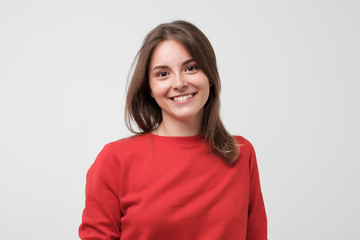 Portrait of young beautiful gcaucasian woman in red t-shirt cheerfuly smiling looking at camera. Studio photo isolated on white background. Copy space.