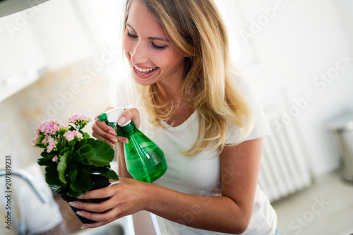 Beautiful young woman watering and caring for flowers