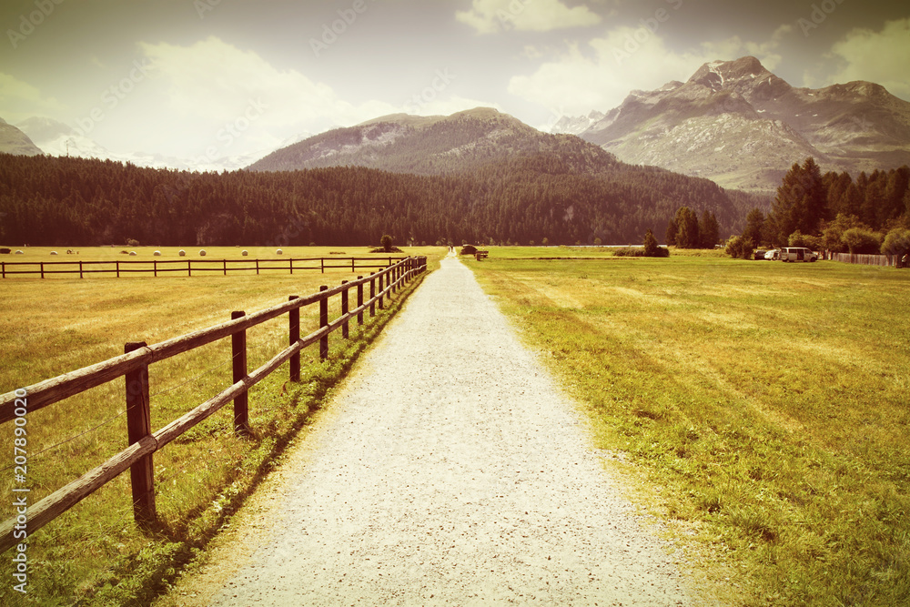 Landscape around Sils Lake on upper Engadine Valley with footpath and wooden palisade (Switzerland - Europe) - Toned with a retro vintage instagram filter effect