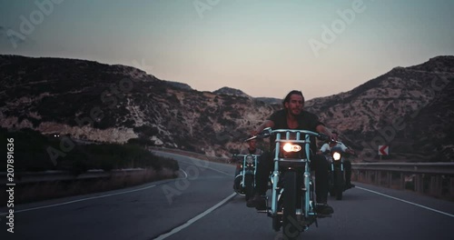 Young rebel men riding motorcycles on mountain road trip