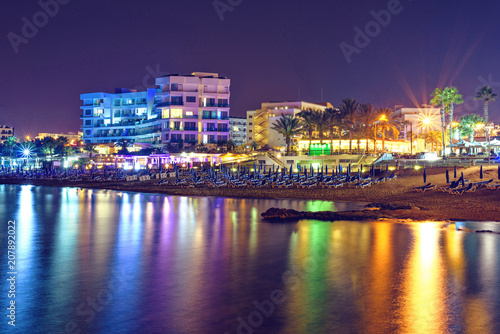 Night cityscape with beachline, lights glowing on buildings