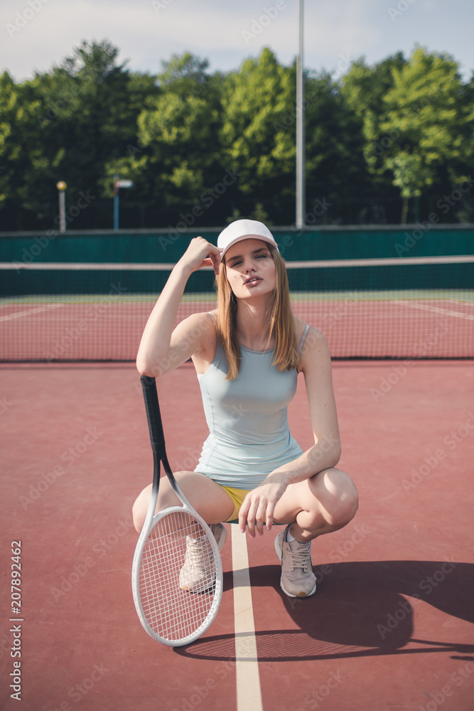 Portrait of young Caucasian teen model wearing fashionable tennis dress,  posing on tennis hardcourt, summer sunny day outdoors. Fashion portrait  shoot Stock Photo | Adobe Stock