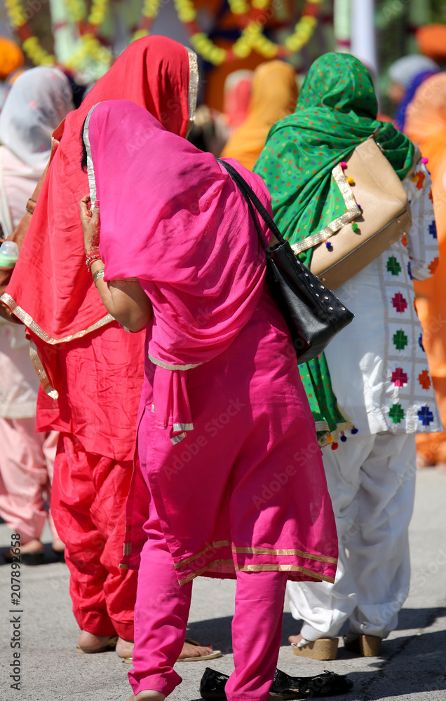 young sikh women with colored dress in the street during religio