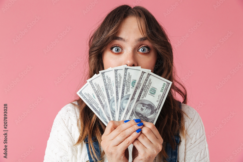 Portrait of a shocked young girl holding money Portrait of a shocked young girl holding money