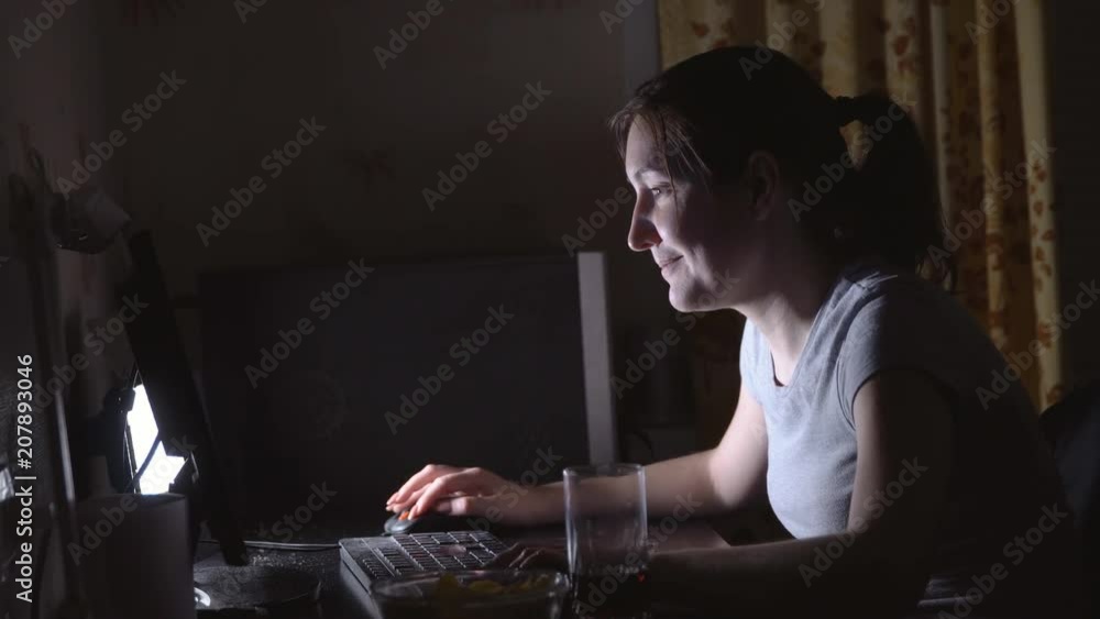 Young woman playing computer games with chips and drinks. Young woman playing computer games with chips and drinks.