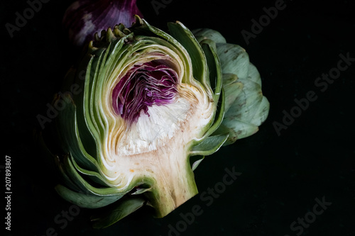 Close up of artichoke against black background photo